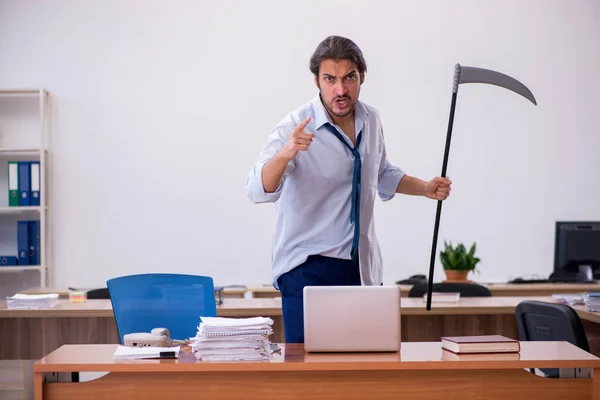 Junger männlicher wütender Angestellter mit Axt im Büro — Stockfoto