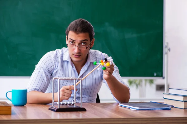 Junger männlicher Physiklehrer vor der Tafel — Stockfoto