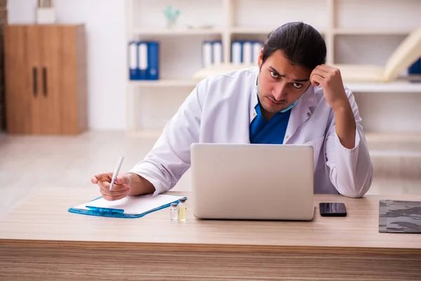 Jonge mannelijke arts werkzaam in de kliniek — Stockfoto