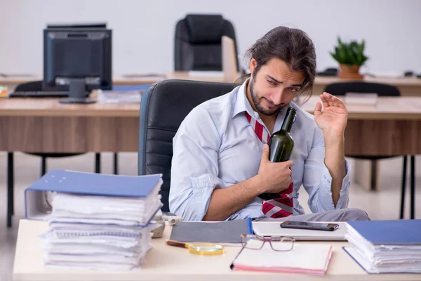 Junge männliche Angestellte trinkt Alkohol im Büro — Stockfoto