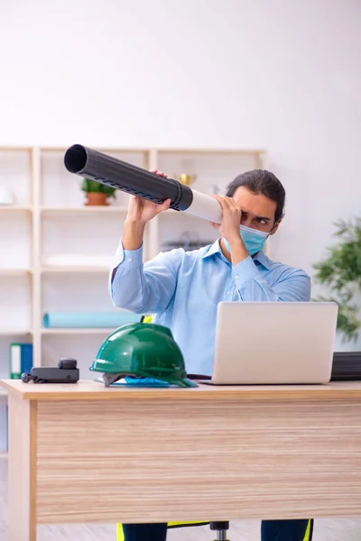 Joven arquitecto masculino trabajando en la oficina durante una pandemia — Foto de Stock