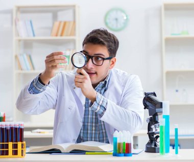 Laboratuvarda kimyasallar üzerinde çalışan genç bir kimyager.