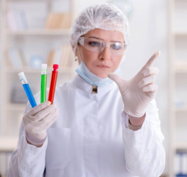 Laboratuvarda sanal düğmeye basan kadın kimyager.