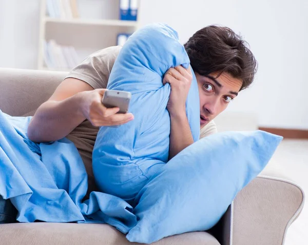 Man watching tv from bed holding remote control unit — Stock Photo, Image