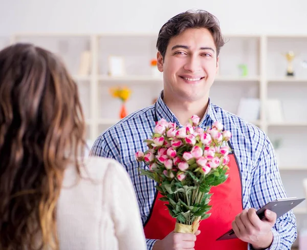 Asistente de floristería vendiendo flores a cliente femenino — Foto de Stock