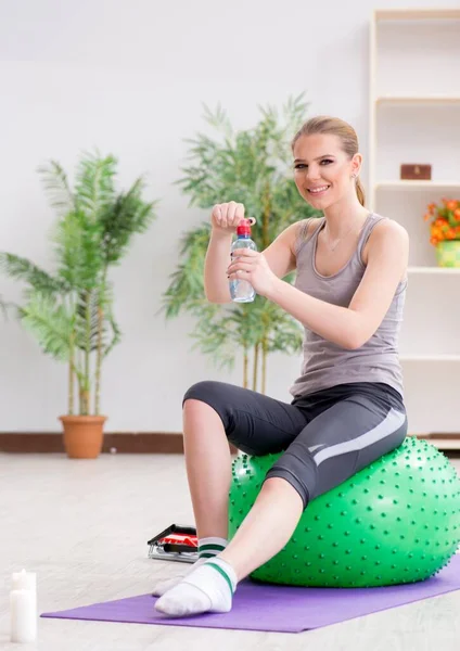 Young woman exercising with stability ball in gym — Stock Photo, Image