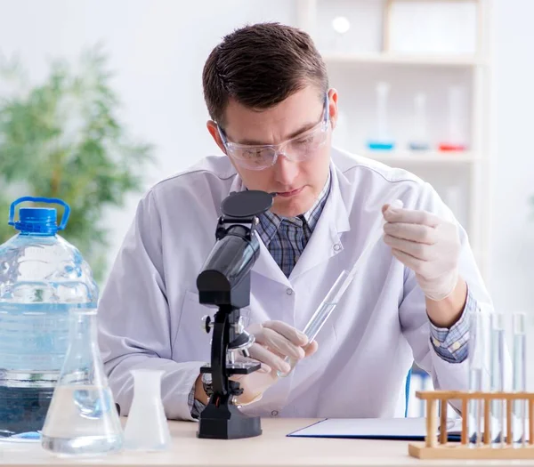 Jeune étudiant chimiste expérimentant en laboratoire — Photo