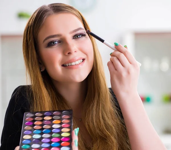 Mujer joven aplicando maquillaje preparándose para la fiesta —  Fotos de Stock