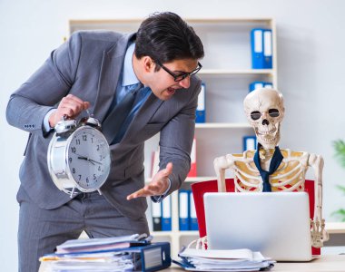 Kızgın patron iskelet çalışanına bağırıyor.