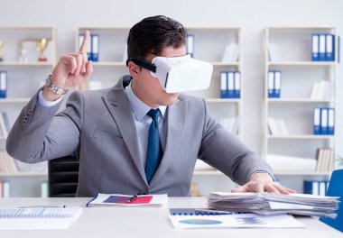 Ofiste sanal gerçeklik gözlüklü bir iş adamı var.