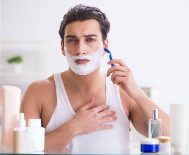 Genç yakışıklı adam sabah erkenden tıraş oluyor.