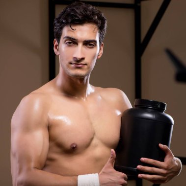 Spor salonunda besin takviyesi olan bir adam.