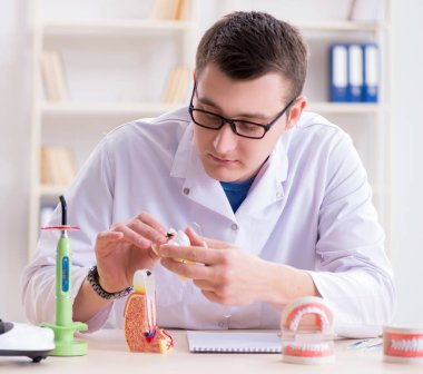 Tıp laboratuarına diş implantı yerleştiren dişçi.