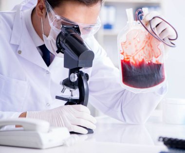 Hastane kliniğinde kan örnekleriyle çalışan bir doktor.