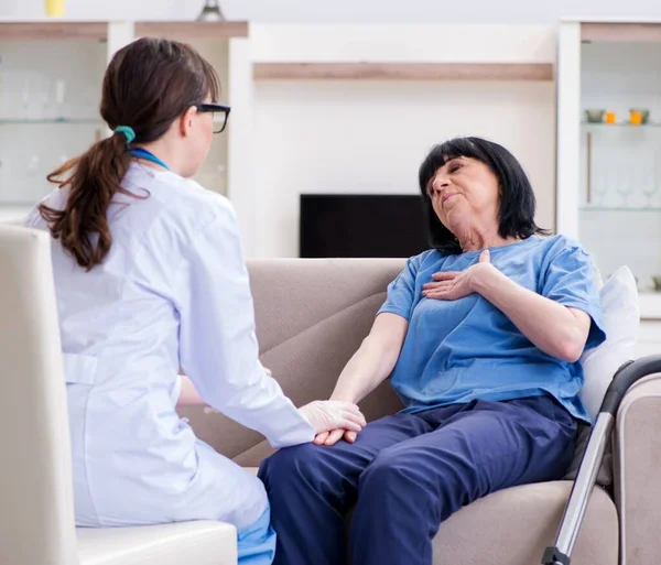 Jonge arts bezoekt oude volwassen vrouw voor check-up — Stockfoto