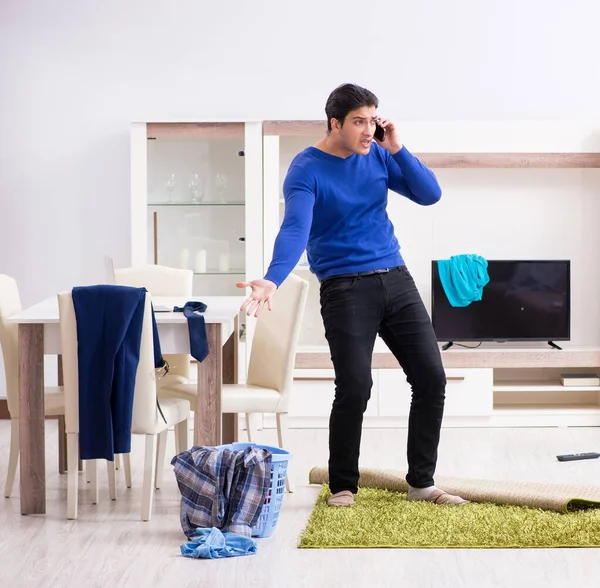 Young man collecting dirty clothing for laundry — Stock Photo, Image