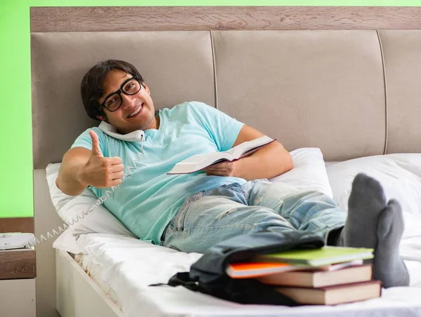 Estudante se preparando para exames em casa no quarto deitado na cama — Fotografia de Stock