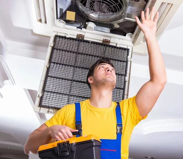 Reparador reparando la unidad de aire acondicionado del techo — Foto de Stock