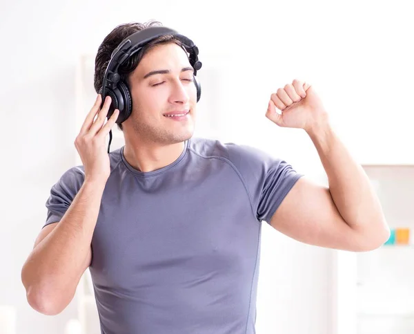 Мужчина занимается спортом дома и слушает музыку — стоковое фото