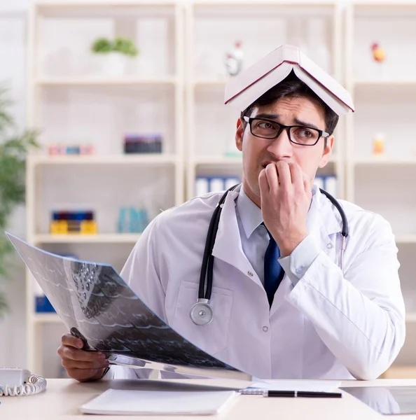 Young doctor looking at x-ray images in clinic — Stock Photo, Image