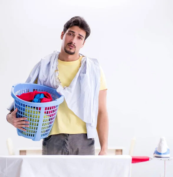 Bonito homem marido fazendo roupas de engomar em casa — Fotografia de Stock