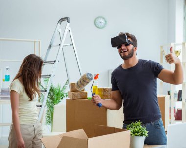 Sanal gözlüklü genç bir aile, Bo ile birlikte yeni evde bavullarını boşaltıyorlar.