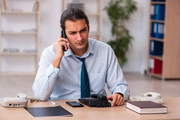 Jovem operador de call center do sexo masculino trabalhando em sua mesa — Fotografia de Stock