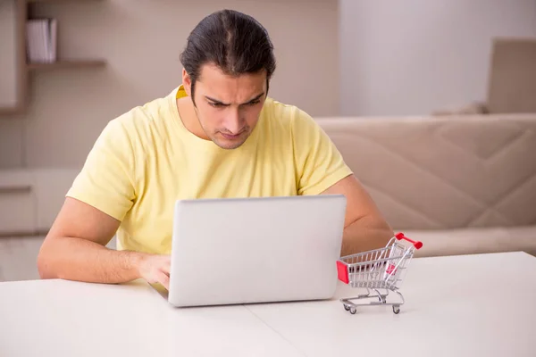 Jovem no conceito de e-commerce em casa — Fotografia de Stock