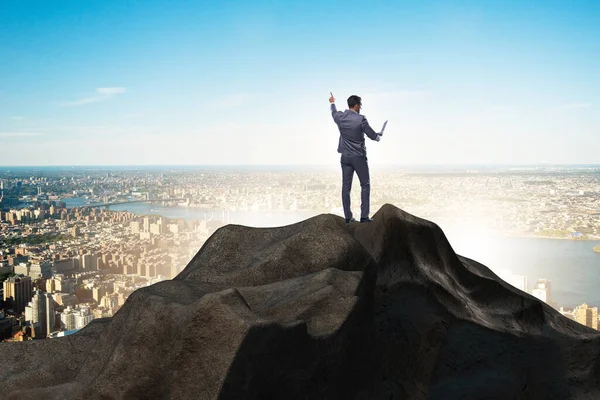 Businessman at the top of mountain in career concept — Stock Photo, Image