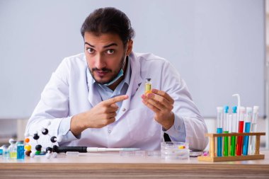 Sınıfta oturan genç erkek kimya öğretmeni.