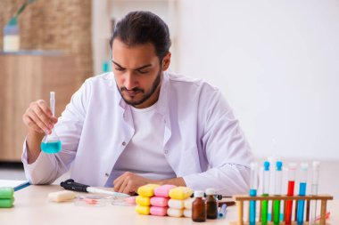 Genç erkek kimyager laboratuarda sabun test ediyor.