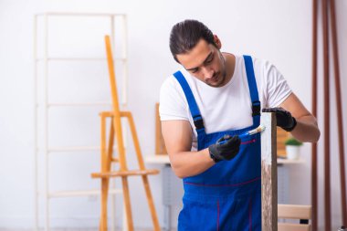 Genç erkek müteahhit atölyede çalışıyor.