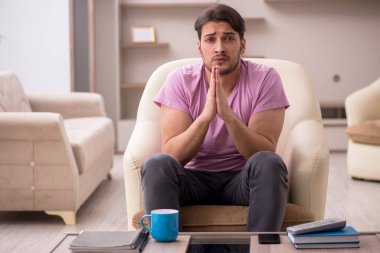 Salgın sırasında evde oturan genç adam.