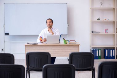 Genç erkek doktor sınıfta seminer veriyor.