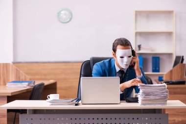 Ofiste maske takan genç bir erkek.