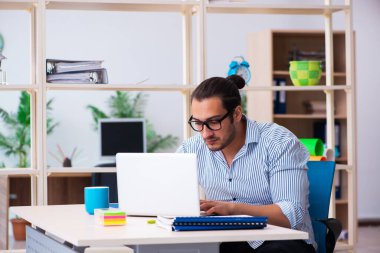 Ofiste çalışan genç bir erkek.