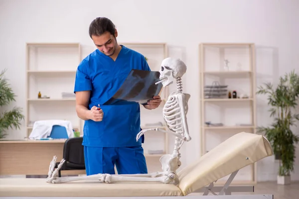 Jeune homme médecin et patient squelette dans le concept antitabac — Photo