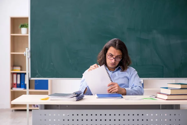 Jonge mannelijke leraar in de voorkant van groene boord — Stockfoto