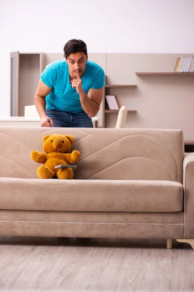 Young man sitting with bear toy at home — Stock Photo, Image