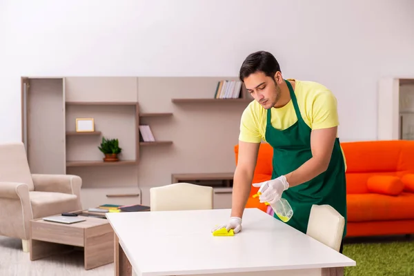 Joven contratista masculino limpiando la casa en interiores — Foto de Stock