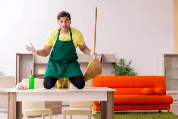 Joven contratista masculino limpiando la casa en interiores — Foto de Stock