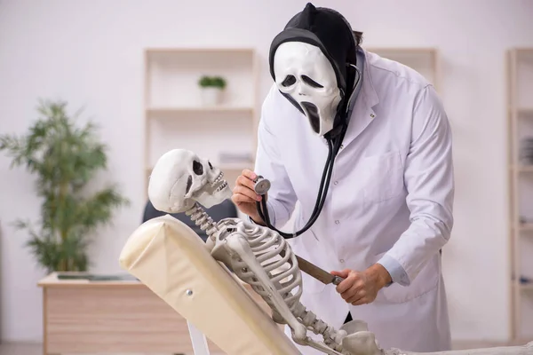 Djävulsk läkare undersöker skelett patient — Stockfoto
