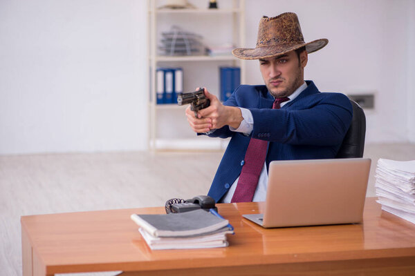 Young cowboy businessman working at workplace