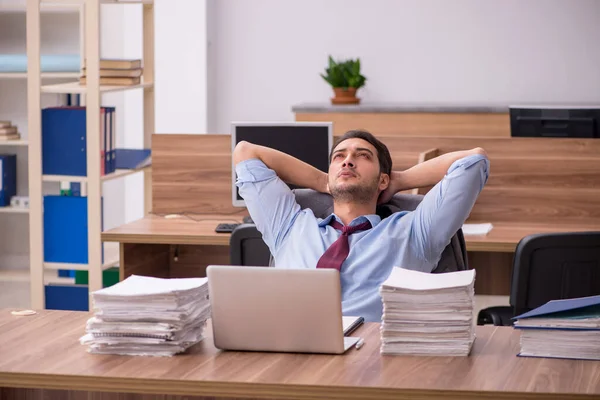 Jovem funcionário masculino infeliz com excesso de trabalho no escritório — Fotografia de Stock