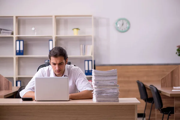 Joven empleado masculino descontento con el trabajo excesivo en la oficina —  Fotos de Stock