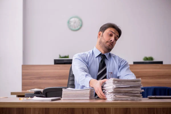 Junge männliche Mitarbeiter und zu viel Arbeit im Büro — Stockfoto