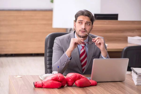 職場でボクシンググローブを身に着けている若い男性従業員 — ストック写真
