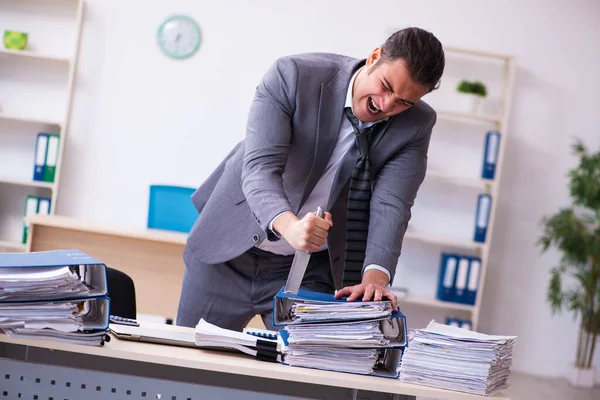 Jovem funcionário irritado com excesso de trabalho segurando faca — Fotografia de Stock