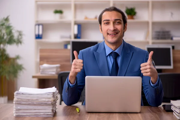 Jonge mannelijke werknemer en veel werk op kantoor — Stockfoto