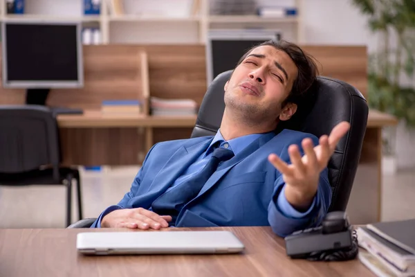 Junge männliche Mitarbeiter und viel Arbeit im Büro — Stockfoto